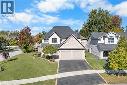 Traditional home with a front yard, asphalt driveway, and a shingled roof - 