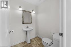 Half bath with toilet and light tile patterned flooring - 