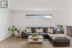 Upper-level bonus room enhanced by a transom window and open railing, creating a bright and airy atmosphere - 