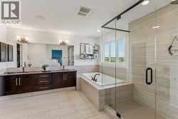 Luxurious 5-piece ensuite featuring a relaxing soaker tub, custom tile shower, and a walk-through closet that connects directly to the laundry room - 