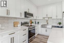 Stainless steel appliances including an electric range, french door refrigerator, built-in microwave, dishwasher and farmhouse sink - 