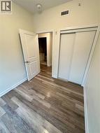 Unfurnished bedroom with wood finished floors and a closet - 