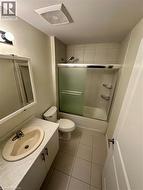 Bathroom with vanity, shower / bath combination with glass door, and light tile patterned flooring - 