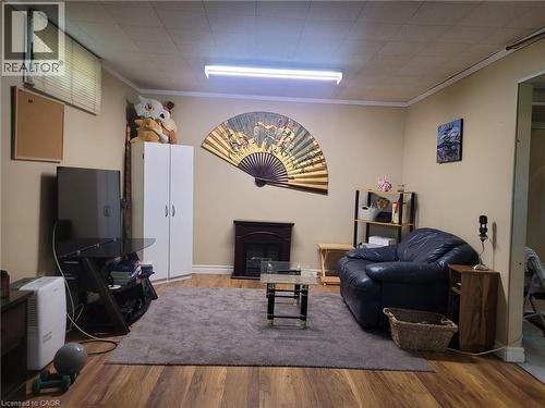 Living room featuring ornamental molding, wood finished floors, and a fireplace - 89 Deschene Avenue, Hamilton, ON - Indoor