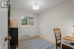 Office space featuring light wood-type flooring, a textured ceiling, and baseboard heating - 