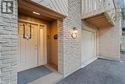 Entrance to property with asphalt driveway, brick siding, and a garage - 