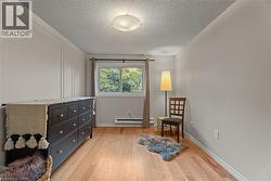 Living area featuring light wood finished floors and a textured ceiling - 