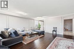 Living area featuring wood finished floors, ornamental molding, and stairway - 