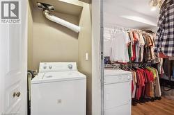 Laundry area with washer / clothes dryer and wood finished floors - 