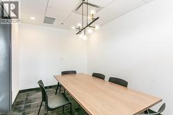 Office area with a drop ceiling and a chandelier - 