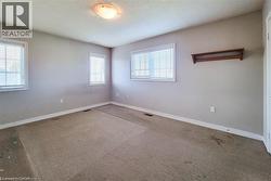 Carpeted empty room with plenty of natural light and a textured ceiling - 