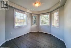 Empty room with wood finish floors and a raised ceiling - 