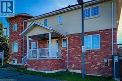 Traditional-style home with brick siding, stucco siding, and covered porch - 