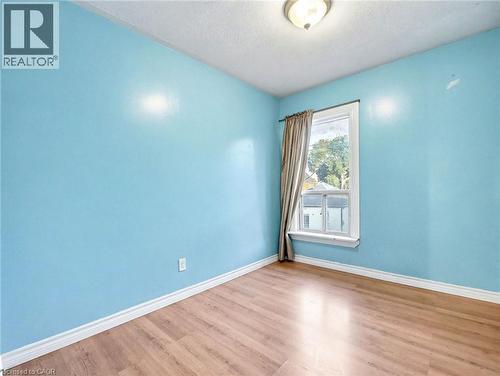 Empty room with wood finished floors and a textured ceiling - 23 Oak Avenue, Hamilton, ON - Indoor Photo Showing Other Room