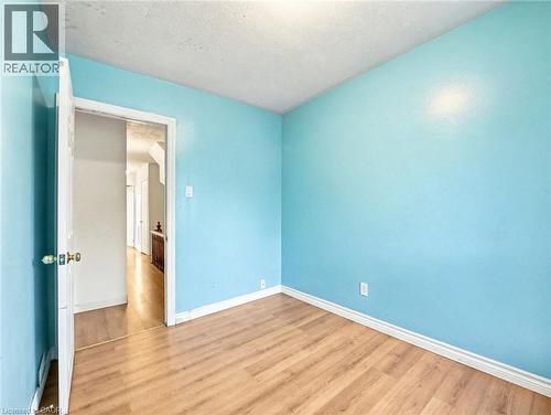 Spare room featuring wood finished floors and a textured ceiling - 23 Oak Avenue, Hamilton, ON - Indoor Photo Showing Other Room