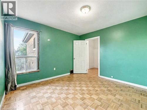 Unfurnished bedroom featuring baseboards and a textured ceiling - 23 Oak Avenue, Hamilton, ON - Indoor Photo Showing Other Room