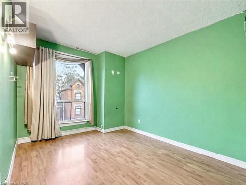 Spare room featuring wood finished floors and a textured ceiling - 23 Oak Avenue, Hamilton, ON - Indoor Photo Showing Other Room