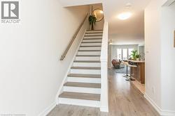 Staircase to top floor featuring wood finished floors and baseboards - 