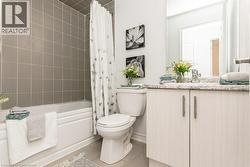 Main 4 pc Bathroom featuring tile patterned floors, vanity, and shower / bath combination with curtain - 