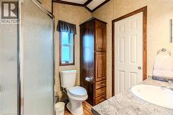 Bathroom featuring vanity, a shower stall, ornamental molding, and light wood finished floors - 