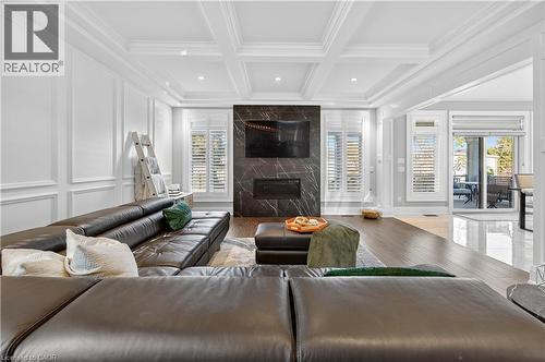 Living room featuring a fireplace, beam ceiling, coffered ceiling, wood finished floors, and recessed lighting - 18 David Avenue, Hamilton, ON - Indoor Photo Showing Living Room With Fireplace