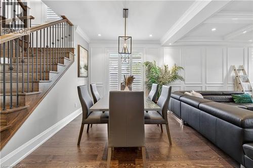 Dining space featuring dark wood-style floors, a decorative wall, ornamental molding, recessed lighting, and stairs - 18 David Avenue, Hamilton, ON - Indoor