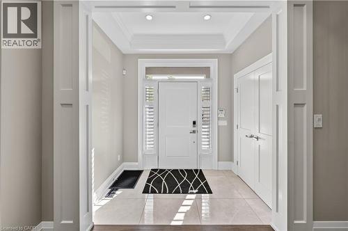 Foyer featuring light tile patterned floors, ornamental molding, and a tray ceiling - 18 David Avenue, Hamilton, ON - Indoor Photo Showing Other Room