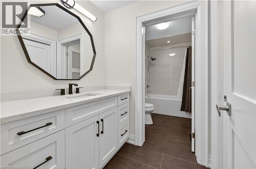 Full bathroom with shower / bath combination with curtain, vanity, and wood tiled floors - 18 David Avenue, Hamilton, ON - Indoor Photo Showing Bathroom