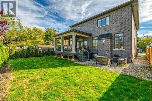 Back of property with a fenced backyard, brick siding, and a patio area - 18 David Avenue, Hamilton, ON - Outdoor