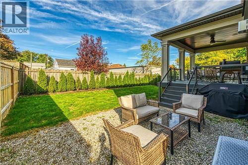 Fenced backyard featuring a patio area, a ceiling fan, an outdoor hangout area, grilling area, and a wooden deck - 18 David Avenue, Hamilton, ON - Outdoor With Deck Patio Veranda