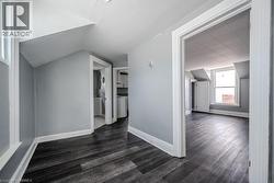 Bonus room featuring dark wood-type flooring, vaulted ceiling, and washer / dryer - 