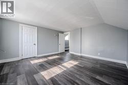 Additional living space with dark wood-type flooring and lofted ceiling - 