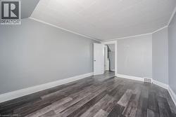 Spare room with vaulted ceiling, crown molding, and dark hardwood / wood-style flooring - 