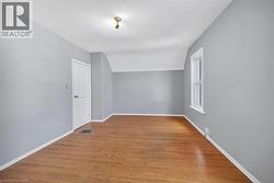 Bonus room featuring light wood-type flooring and baseboards - 