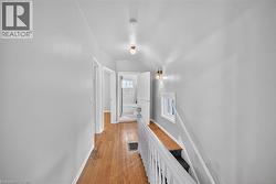 Hall featuring an upstairs landing and light wood-type flooring - 
