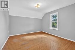 Additional living space featuring light wood-style floors and vaulted ceiling - 