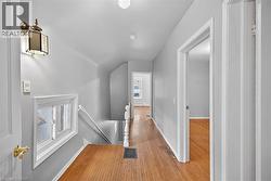 Hall featuring an upstairs landing and wood finished floors - 