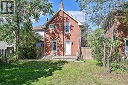 Rear view of house with a chimney, brick siding, and a deck - 