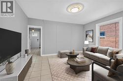 Virtually staged Living room with light tile patterned flooring and plenty of natural light - 