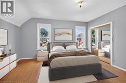 Virtually staged Bedroom featuring light wood finished floors, a closet, and vaulted ceiling - 