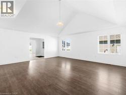 Unfurnished room with high vaulted ceiling and dark wood finished floors - 