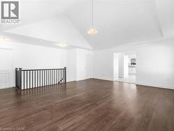 Additional living space featuring high vaulted ceiling and dark wood-style flooring - 