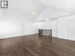 Additional living space featuring high vaulted ceiling and dark wood-style floors - 