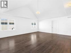 Unfurnished room with high vaulted ceiling and dark wood-style floors - 