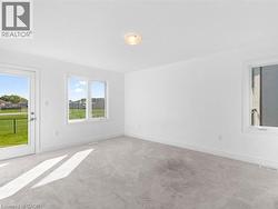 Unfurnished room featuring healthy amount of natural light and light colored carpet - 