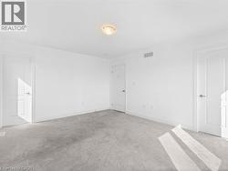 Unfurnished bedroom featuring light carpet and baseboards - 
