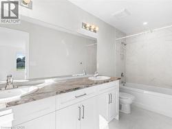 Full bathroom featuring shower / bathtub combination, double vanity, and light marble finish floors - 