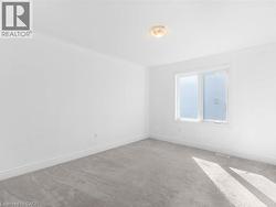 Empty room with light carpet and baseboards - 