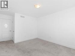 Empty room with light colored carpet and baseboards - 
