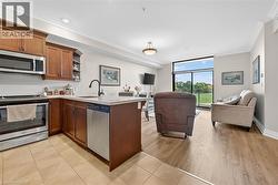 Kitchen with stainless steel appliances, ornamental molding, expansive windows, tasteful backsplash, and a peninsula - 